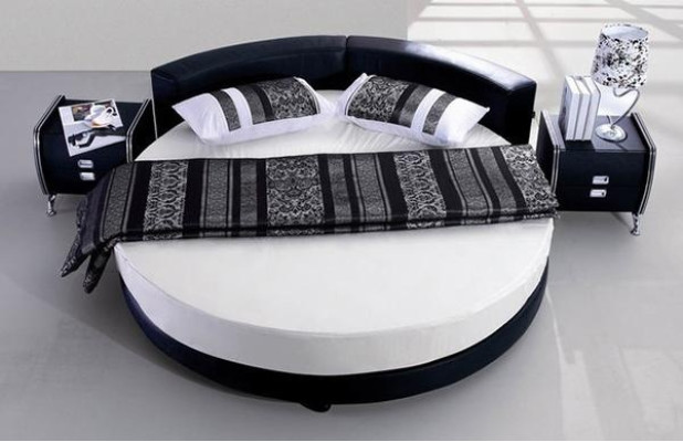 Moderna cama negra con detalles elegantes y un sofá