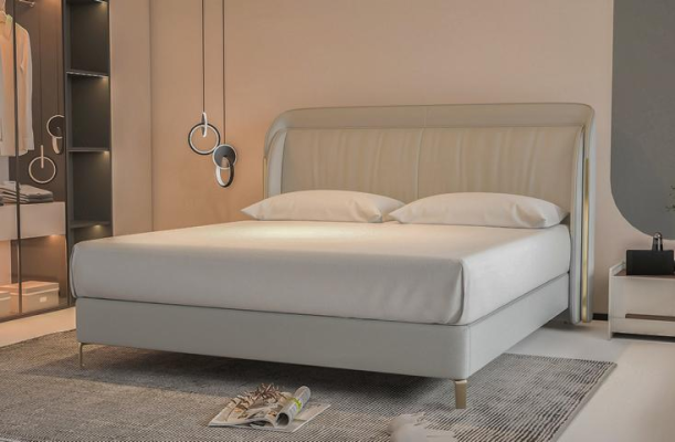 Moderna cama de lujo en gris con un elegante cabecero dorado