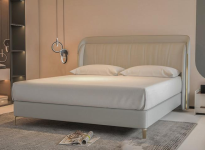 Moderna cama de lujo en gris con un elegante cabecero dorado