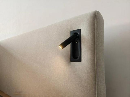 Cama tapizada beige en estilo hotel moderno con iluminación LED y cabecera lujosa