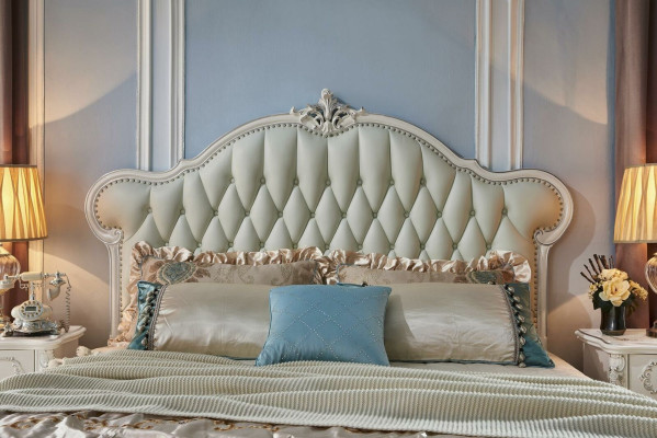 Elegante cama Chesterfield en estilo clásico con mesitas de noche a juego.