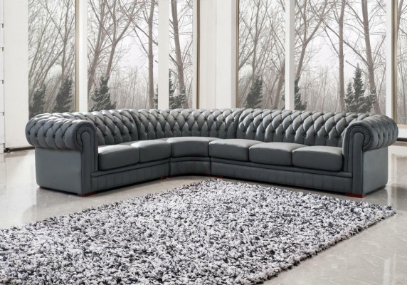 Sofá esquinero clásico Chesterfield tapizado en cuero con decoración de costuras.