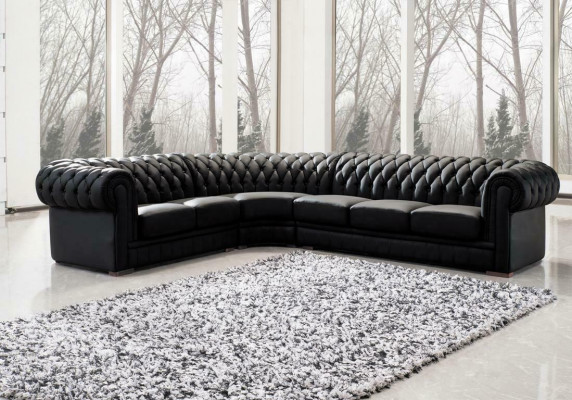 Sofá esquinero clásico Chesterfield tapizado en cuero con decoración de costuras.
