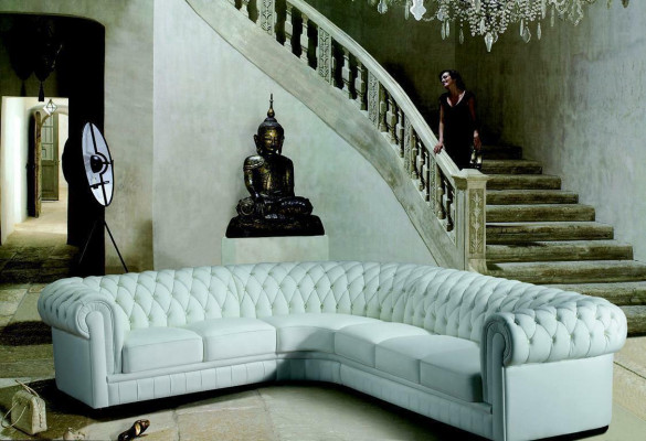 Sofá esquinero clásico Chesterfield tapizado en cuero con decoración de costuras.