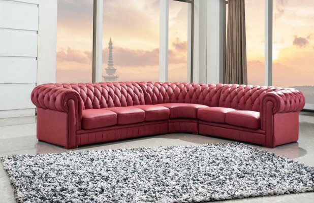 Sofá esquinero clásico Chesterfield tapizado en cuero con decoración de costuras.