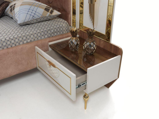 Elegante cama de confort Chesterfield con patas doradas y mesitas de noche a juego.