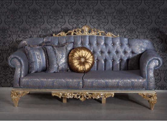 Sofá clásico y exigente en diseño Chesterfield para la sala de estar con cojines dorados.