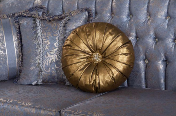 Sofá clásico y exigente en diseño Chesterfield para la sala de estar con cojines dorados.