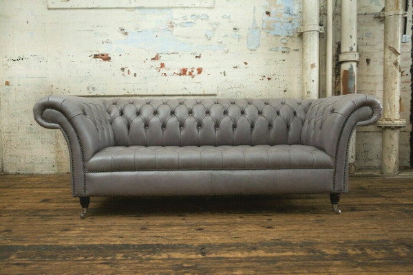 Sofá Chesterfield gris de tres plazas exclusivo para la sala de estar.