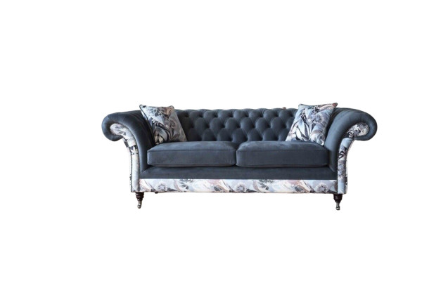 Un llamativo sofá de tres plazas en diseño Chesterfield con delicada decoración de flores grises.