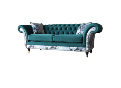 Un sofá de tres plazas de Chesterfield en un vibrante color esmeralda con estampado floral.