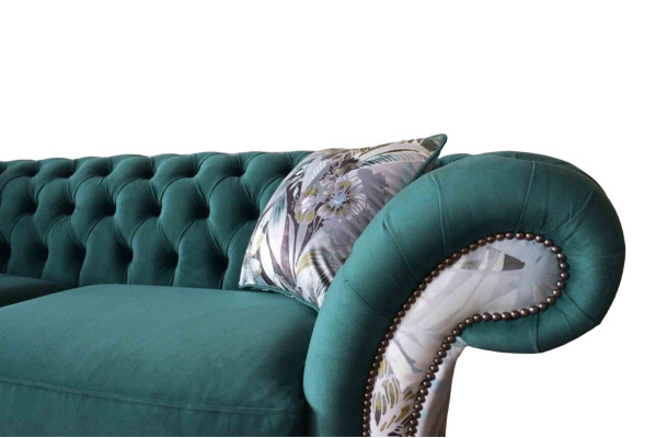 Un sofá de tres plazas de Chesterfield en un vibrante color esmeralda con estampado floral.