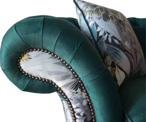 Un sofá de tres plazas de Chesterfield en un vibrante color esmeralda con estampado floral.