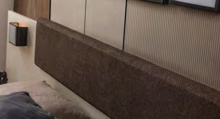 Conjunto exclusivo de dormitorio de diseñador. Cama beige con mesitas de noche marrones.