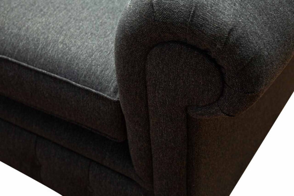 Sofá Chesterfield tapizado de dos plazas en tela gris.
