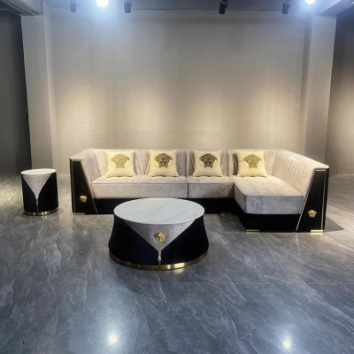 Muebles de sala gris: sofá de esquina, mesa de centro, mesita auxiliar de acero inoxidable.