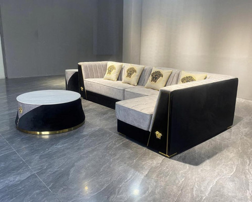 Muebles de sala gris: sofá de esquina, mesa de centro, mesita auxiliar de acero inoxidable.