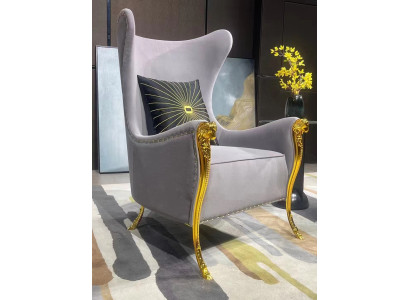 Sillón de lujo con elementos decorativos y patas doradas.