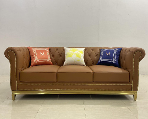 Sofá Chesterfield de tres plazas con estructura de acero inoxidable y tapizado textil.
