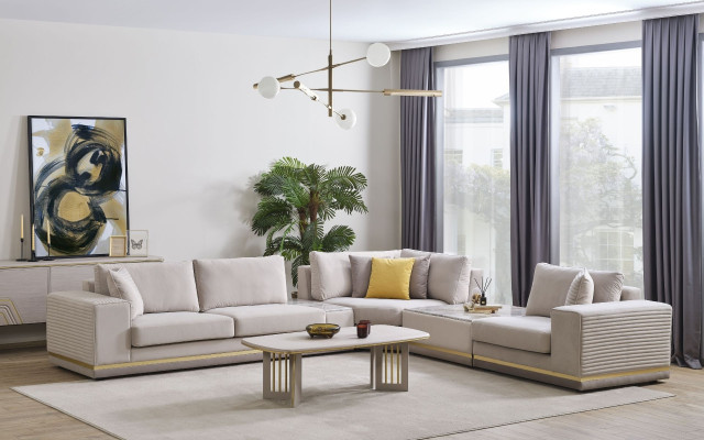 Sofá esquinero moderno en forma de L de textil color beige claro para sala de estar.