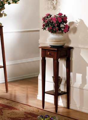 Soporte de flores de madera en color marrón con cajón y estante.