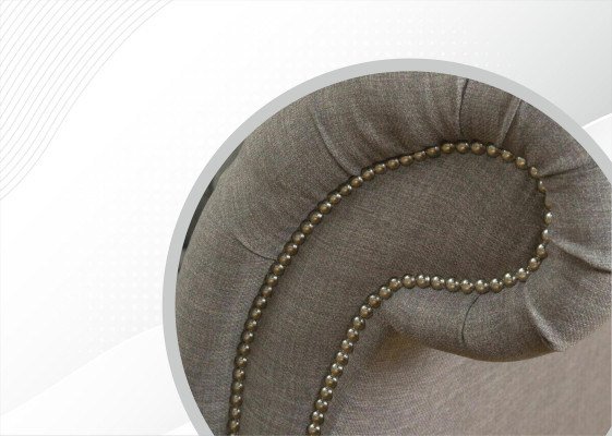 Sofá Chesterfield gris tapizado en tela de cuero y terciopelo.