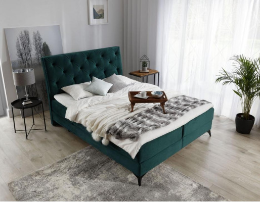 Cama boxspring de lujo de tela verde de hotel. Muebles de dormitorio de diseño en terciopelo nuevo.
