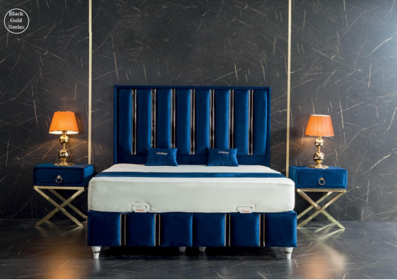 Cama de diseñador azul zafiro con mesitas de noche en patas de acero dorado.
