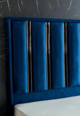 Cama de diseñador azul zafiro con mesitas de noche en patas de acero dorado.