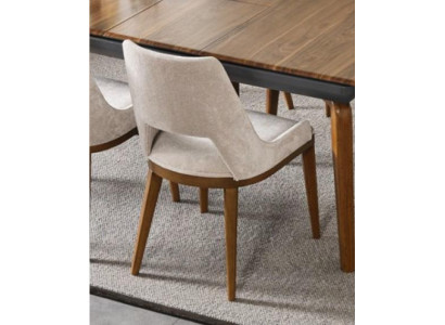 Una silla lacónica y moderna con patas altas de madera y tapizado en un agradable color crema claro para el comedor.