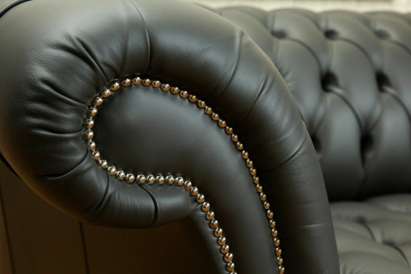 Sofá grande de 4 plazas Chesterfield gris de tela y cuero con cojines.