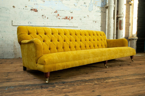 Sofá Chesterfield clásico de 4 plazas en cuero amarillo diseño tapizado.