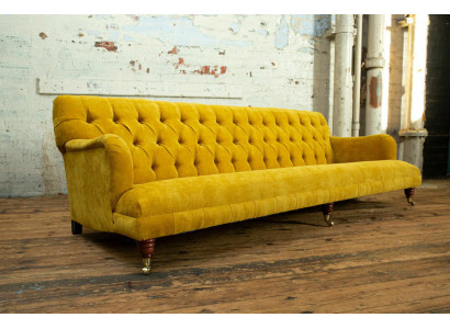 Sofá Chesterfield clásico de 4 plazas en cuero amarillo diseño tapizado.