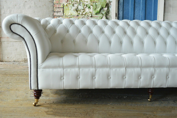 Sofá clásico Chesterfield de 4 plazas en diseño de terciopelo y cuero blanco.