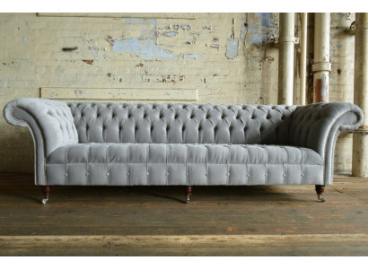 Clásico sofá Chesterfield de 4 plazas en cuero gris de diseño acolchado.