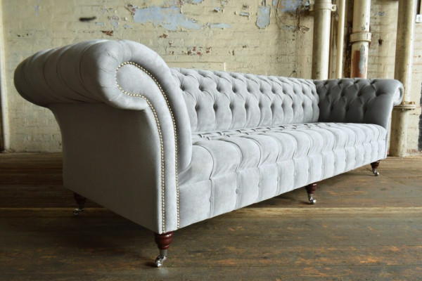 Clásico sofá Chesterfield de 4 plazas en cuero gris de diseño acolchado.