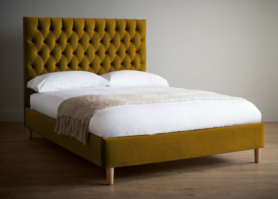Cama doble Chesterfield con cabecero alto y diseño de mostaza.