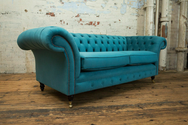 Sofá Chesterfield de diseñador de 3 plazas de lujo en el salón de color turquesa.