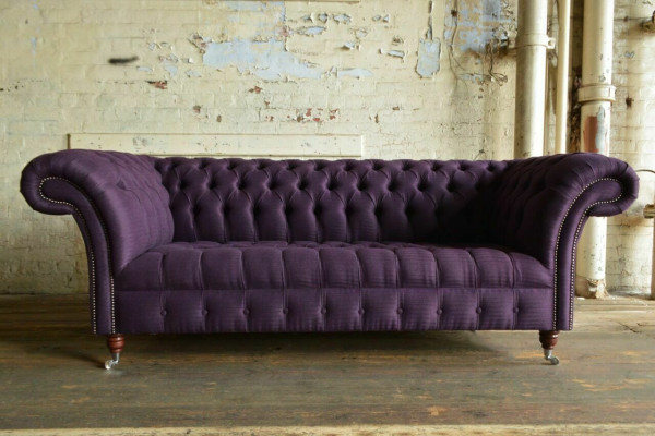Moderno sofá Chesterfield de tres plazas en lila para sala de estar.