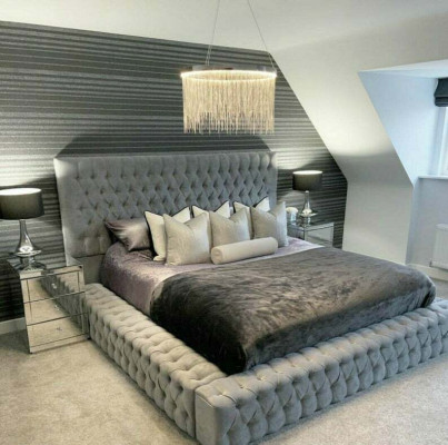 Cama Chesterfield de lujo para habitación de hotel con botones acolchados.