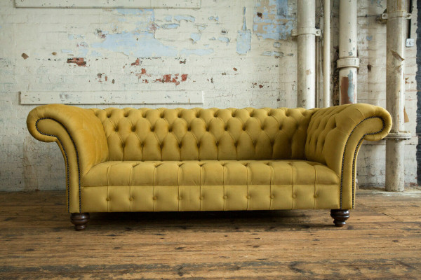 Sofá de lujo de tres plazas Chesterfield de diseñador amarillo para la sala de estar.