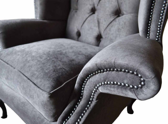 Silla orejera modelo Chesterfield de tela de poliéster gris para sala de estar.