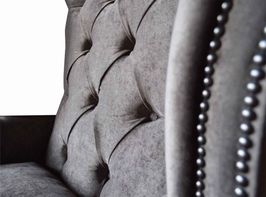 Silla orejera modelo Chesterfield de tela de poliéster gris para sala de estar.