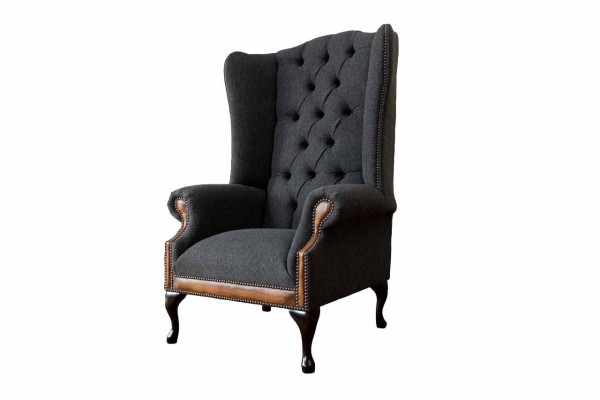 Sillón Chesterfield gris, clásico tapizado de tela en la sala de estar.
