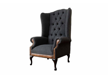Sillón Chesterfield gris, clásico tapizado de tela en la sala de estar.