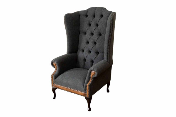 Sillón Chesterfield gris, clásico tapizado de tela en la sala de estar.