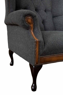 Sillón Chesterfield gris, clásico tapizado de tela en la sala de estar.