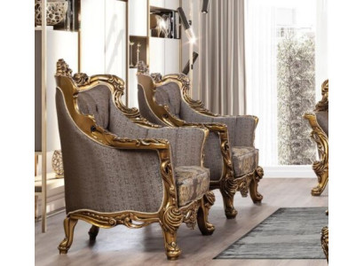 Una lujosa butaca clásica en gris oscuro con diseño barroco dorado de Chesterfield.