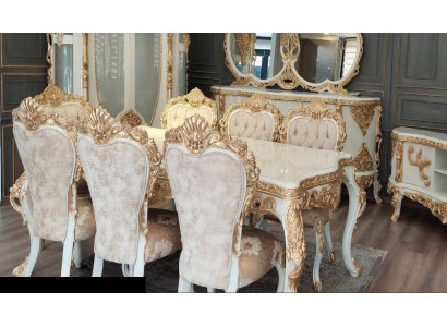 Conjunto clásico de sillas con adornos tallados ricamente decorados en dorado.