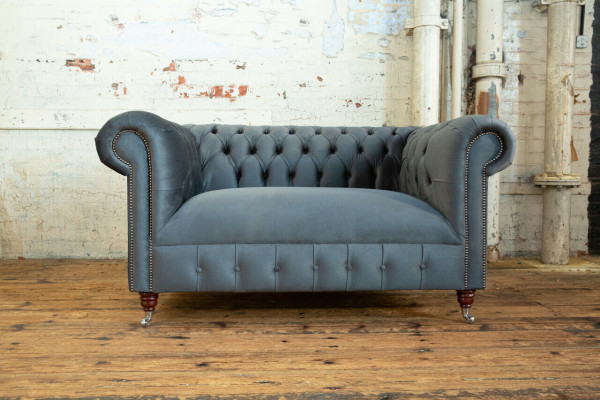 Sofá de diseño Chesterfield 2 plazas, tapizado en piel y textil gris.